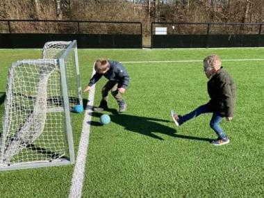 To børn der spiler fodbold 